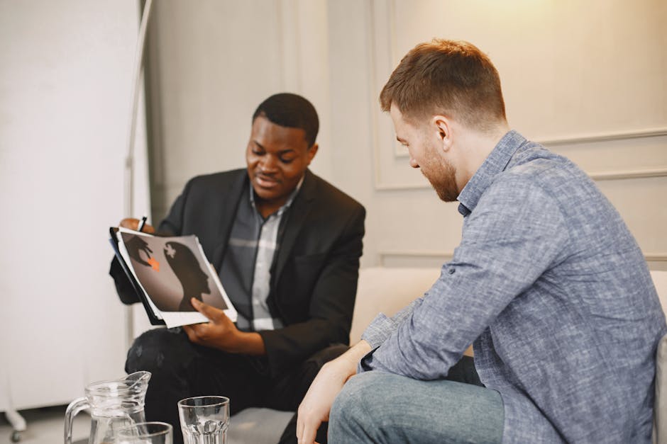 Two professionals in a discussion, exchanging ideas over documents in an office.
